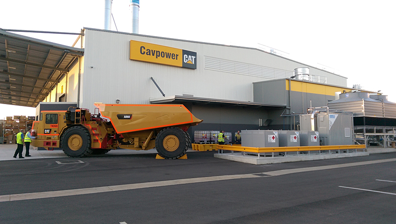 Ein „CAT“ Minenfahrzeug (links) parkt neben der CNG 45 Kompressor- und Speichereinheit von BAUER KOMPRESSOREN (rechts)